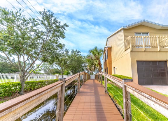 a house on the water with a bridge in front of it