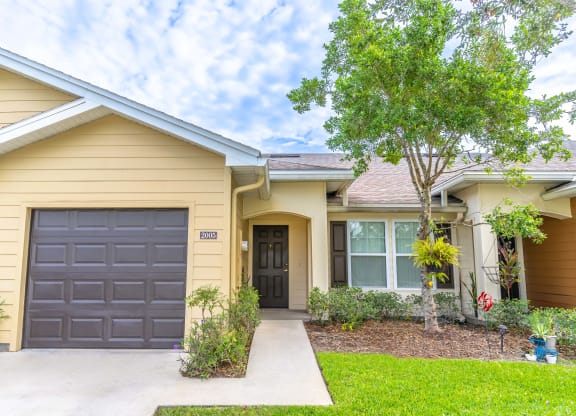 a yellow house with a black garage door