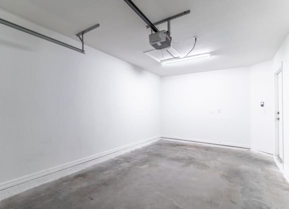 an empty room with white walls and a fluorescent light on the ceiling
