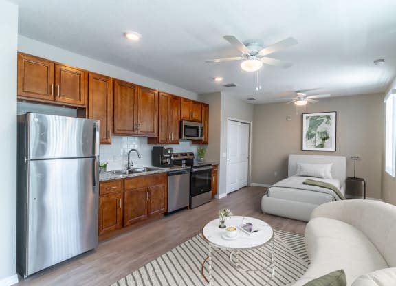 a living room with a white couch and a kitchen with stainless steel appliances