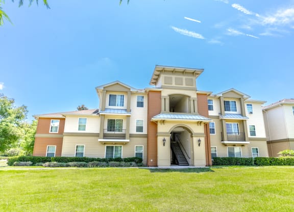 a large apartment building with a grassy area in front of it