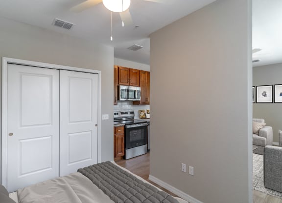 a bedroom with a bed and a view of a kitchen