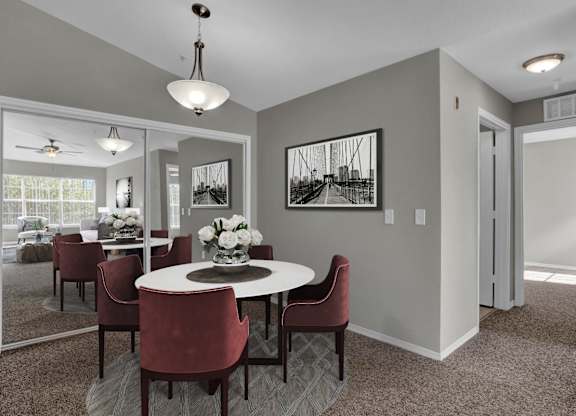 A dining room with a round table and chairs.