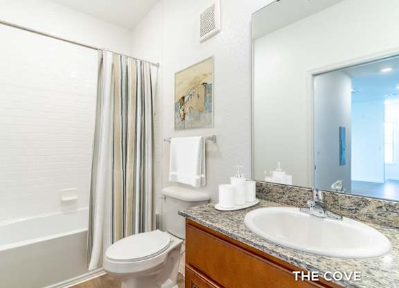 A bathroom with a toilet, sink, and shower.