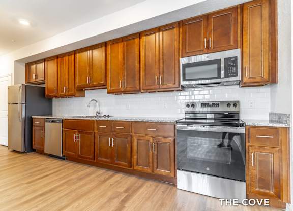A kitchen with wooden cabinets and stainless steel appliances.