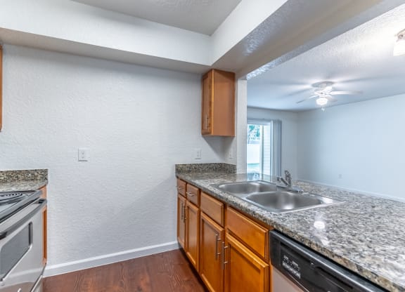a kitchen with granite countertops and wooden cabinets