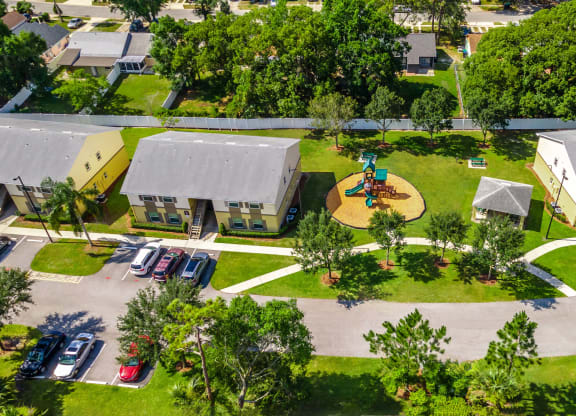 a birdseye view of a playground in the middle of a yard between two buildings