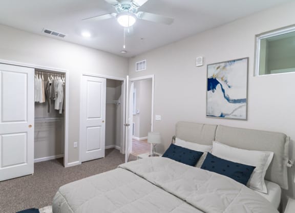 a bedroom with a large bed and a ceiling fan