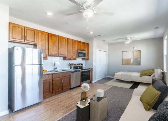 a kitchen and living room with a stainless steel refrigerator