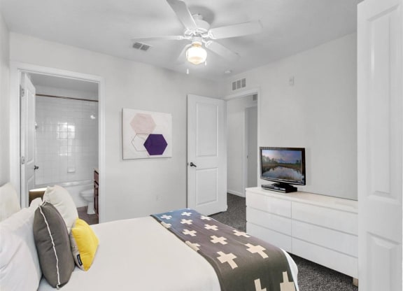 a bedroom with a bed and a ceiling fan