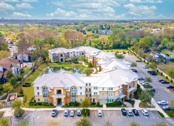 an aerial view of a large building with a fountain in the middle of a parking lot
