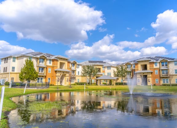 a pond with a fountain in front of a building