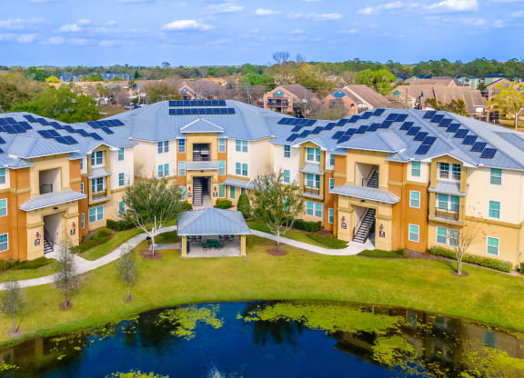 an aerial view of an apartment complex with a pond