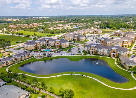 an aerial view of a community with a lake and a swimming pool