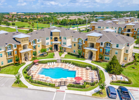 an aerial view of an apartment complex with a swimming pool