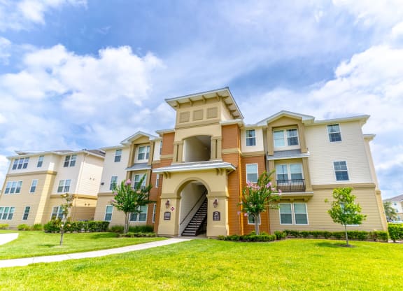 a large apartment building with a grassy area in front of it