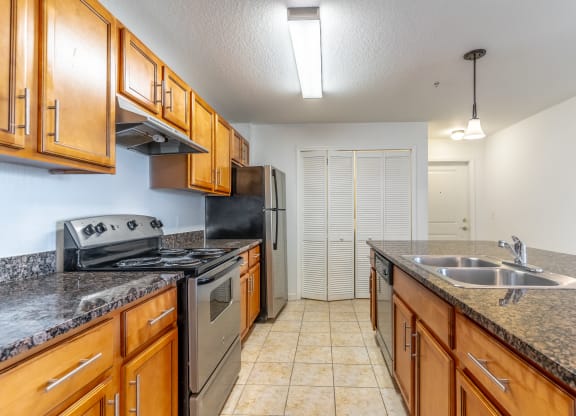 a kitchen with granite countertops and wooden cabinets