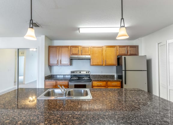 a kitchen with granite countertops and wooden cabinets