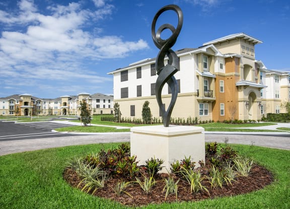 a statue in front of an apartment complex