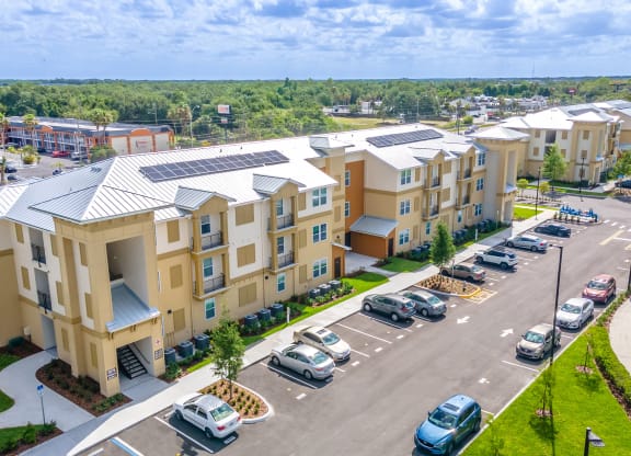 an aerial view of a row of apartment buildings with cars parked in front of them