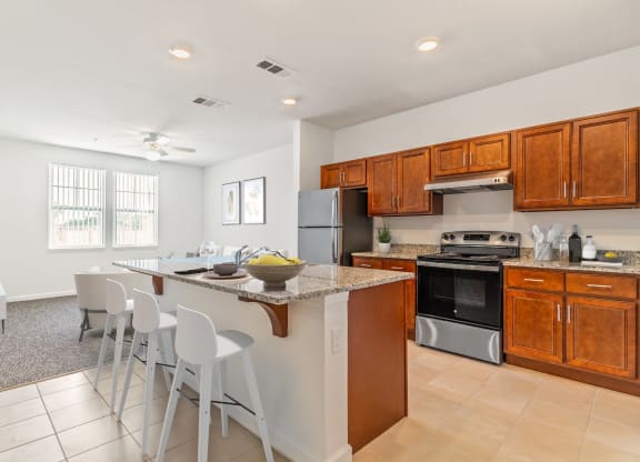 a kitchen with wooden cabinets and a large island with a granite countertop