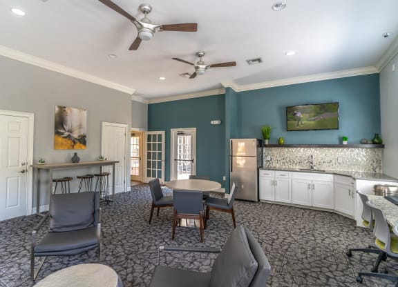 a room with a table and chairs and a kitchenette