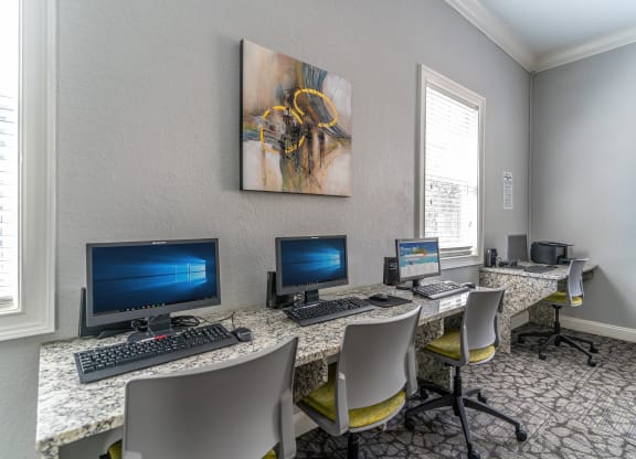 a computer room with three computers and chairs