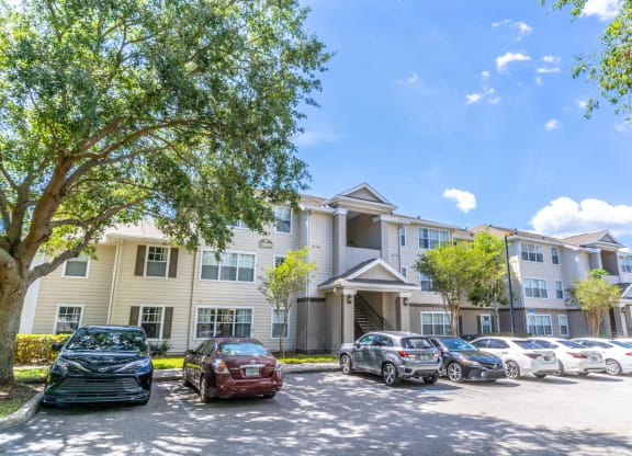 a large apartment building with a parking lot in front of it