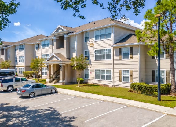 a large apartment building with a parking lot in front of it