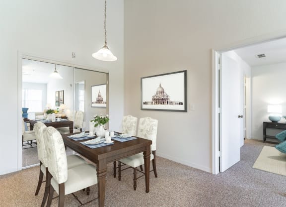 a dining room with a wooden table and white chairs