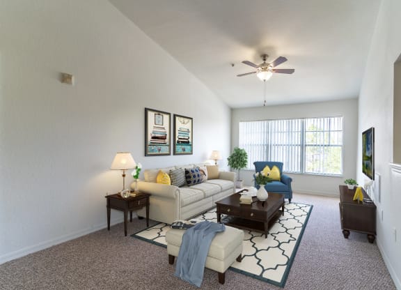 a living room with a ceiling fan and a large window