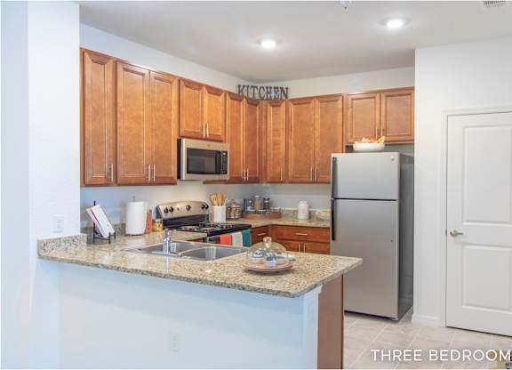 A kitchen with wooden cabinets and a granite countertop.