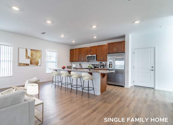 A spacious kitchen with a bar area and a dining table.