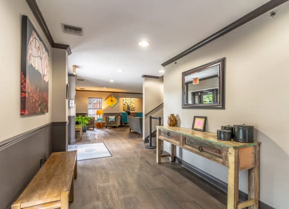 a hallway with benches and a table with a coffee pot on it