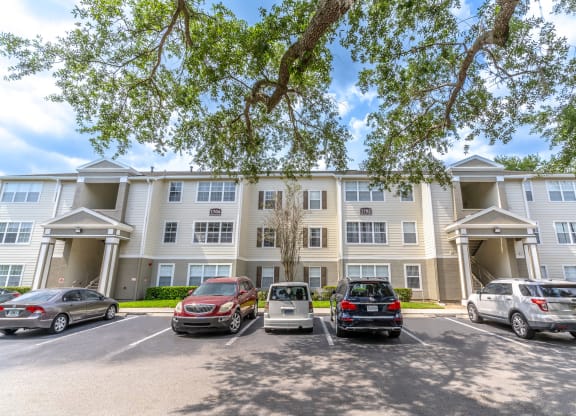 a large apartment building with a parking lot in front of it