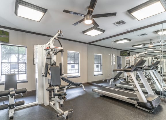 a gym with exercise equipment and windows