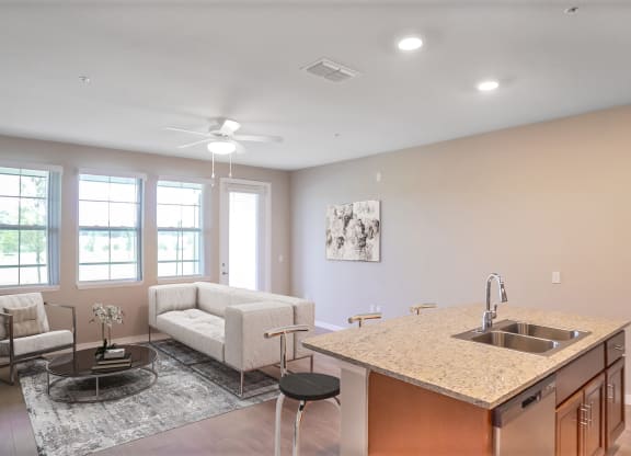the view of a living room and a kitchen with a couch and a table