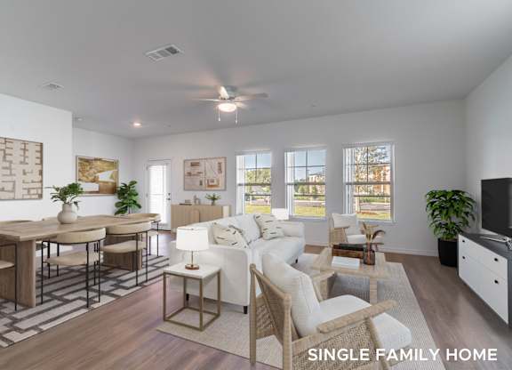 A well-lit, spacious single family home interior with a dining area, living room, and kitchen.