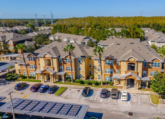 an aerial view of a large apartment complex with cars parked in the parking lot