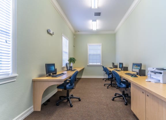 a computer lab with four computers and a printer
