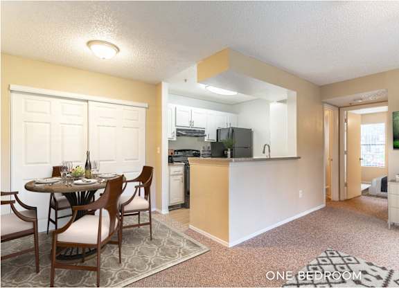 A kitchen with a dining table and chairs in the middle of the room.