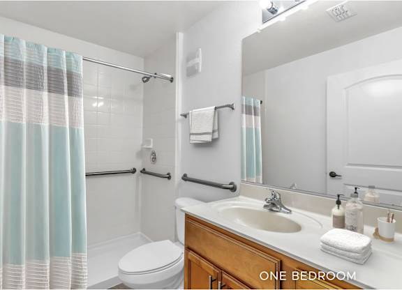 A bathroom with a toilet, sink, and shower.