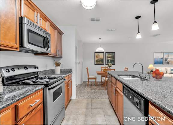 A kitchen with granite countertops and wooden cabinets.