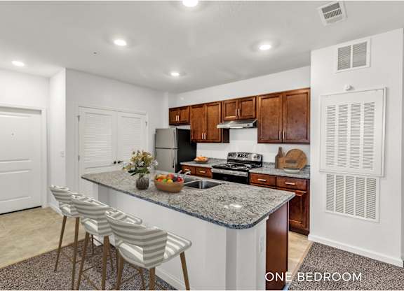 A kitchen with granite countertops and wooden cabinets.