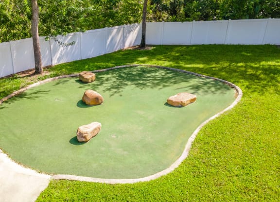 a mini golf court with rocks in the grass