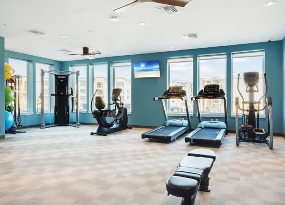 fitness room with cardio equipment and weights