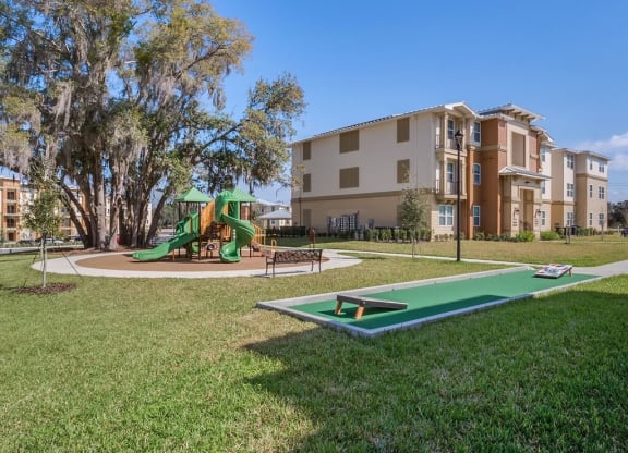 Playground Area and Green Space with cornhole game