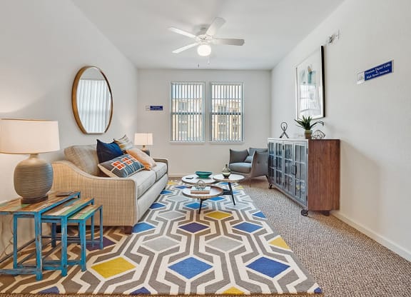a living room with a couch and a ceiling fan