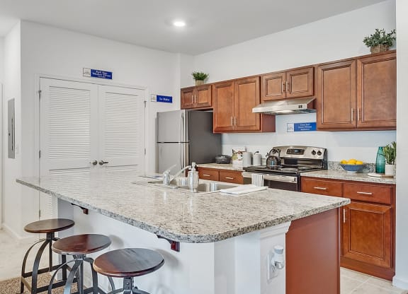 a kitchen with a grantie counter top and wooden cabinets