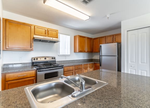 a kitchen with granite countertops and wooden cabinets